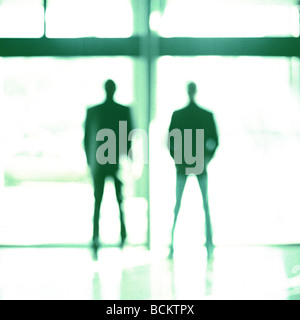 Deux hommes en face de la fenêtre de verre, silhouette Banque D'Images