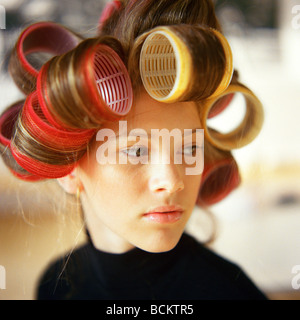 Jeune femme avec des rouleaux dans les cheveux Banque D'Images