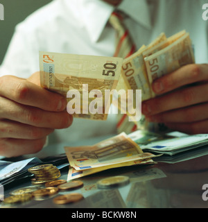 Mains tenant des billets en euros, low angle view Banque D'Images