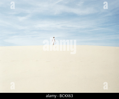 Femme debout sur le sable, à distance Banque D'Images