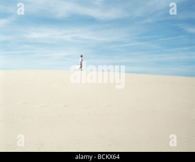 Femme marche sur le sable, à distance Banque D'Images