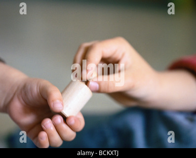 Remise de l'enfant poids en bois de deuxième enfant, close-up of hands Banque D'Images