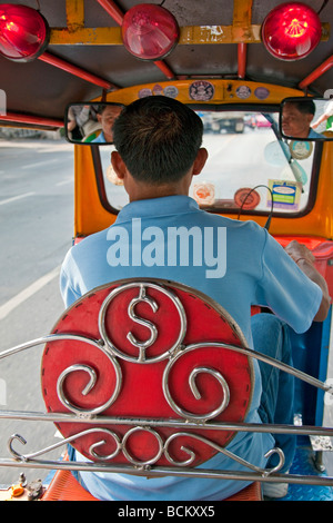 La Thaïlande. Un chauffeur de taxi dans son tuk tuk à deux temps l'un des meilleurs moyens de se déplacer dans la ville de Bangkok congestionnées. Banque D'Images