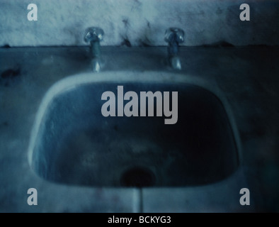 Un vieux lavabo dans l'obscurité Banque D'Images