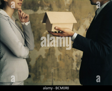 L'homme et la femme debout face à face, man holding out nichoir à Palm Banque D'Images