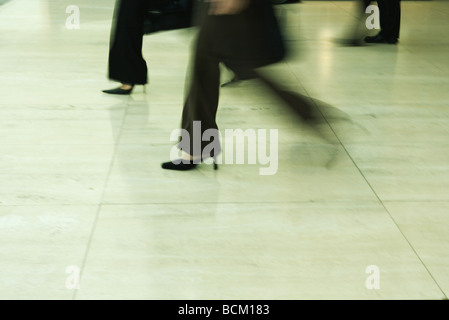 Businesswomen walking, blurred motion, low section Banque D'Images