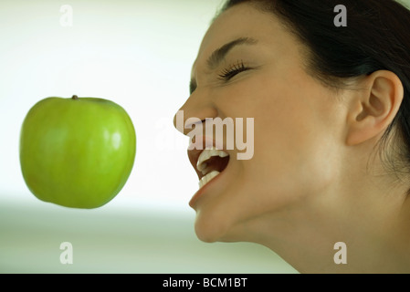 Flottant dans l'air, Apple woman reaching for elle avec la bouche ouverte, les yeux fermés Banque D'Images