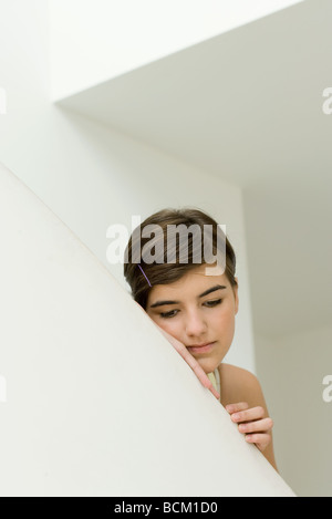 Teen girl leaning on bord de mur, regardant vers le bas Banque D'Images