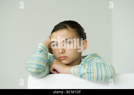 Preteen girl resting head on part, looking at camera Banque D'Images