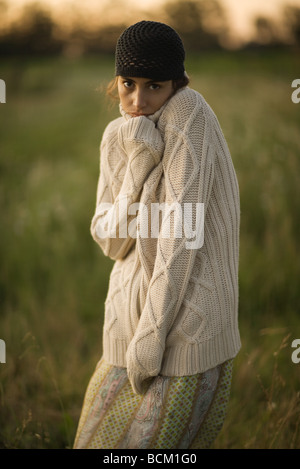 Woman standing outdoors wearing sweater épais, looking at camera, portrait Banque D'Images