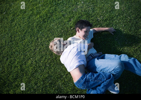 Deux garçons wrestling sur l'herbe, high angle view Banque D'Images