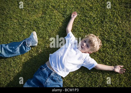 Boy lying on grass, high angle view Banque D'Images