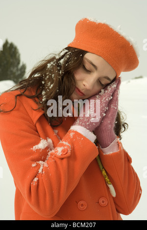 Teenage girl habillé en vêtements d'hiver, tête penchée, à l'extérieur debout sur les mains, les yeux fermés Banque D'Images