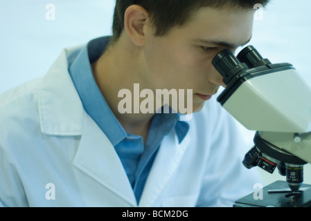 Male scientist looking through microscope, close-up Banque D'Images