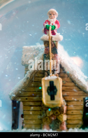 Snow globe avec Santa Claus figurine sur cheminée, close-up Banque D'Images