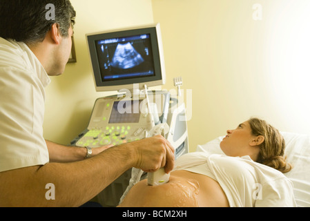 Médecin effectuant échographie de femme enceinte Banque D'Images