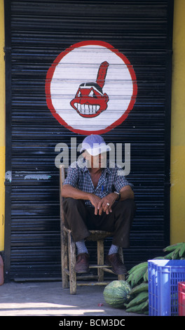 Senior Local assis sur un magasin fermé. La Otra Banda - Caraïbes - République Dominicaine Island Banque D'Images