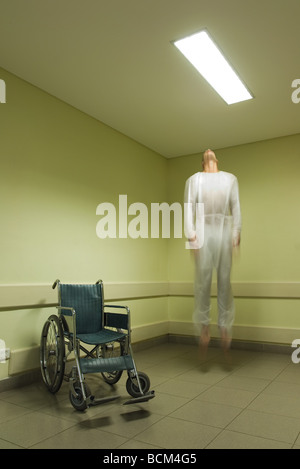 Homme flottant dans l'air près de fauteuil roulant, blurred Banque D'Images