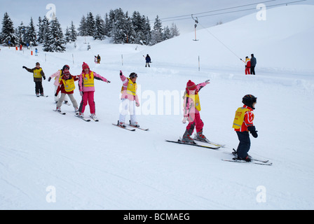 Les jeunes enfants en classe de ski sur la pente de montagne Tyrol Zillertal Banque D'Images