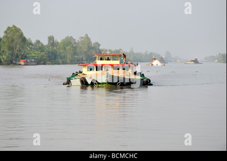 Bateau sur le fleuve du Mékong chargé à pleine capacité avec du sable. Près de Cai Be, Vietnam Banque D'Images