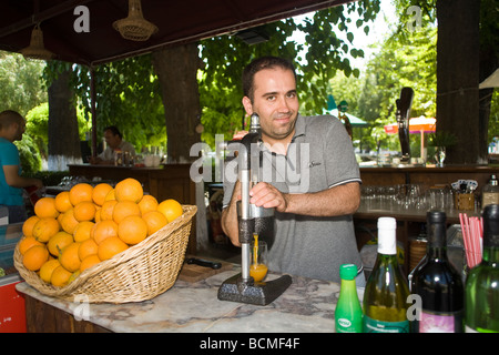 Vendeur tire les oranges de jus pour servir aux touristes. Éphèse. Banque D'Images