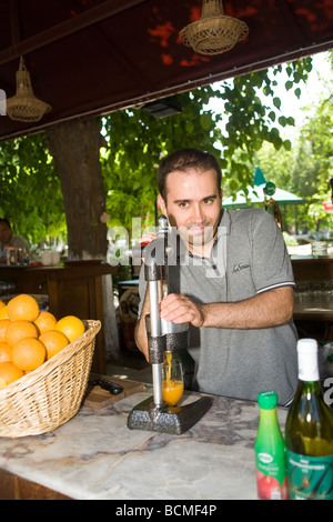 Vendeur tire les oranges de jus pour servir aux touristes. Éphèse. Banque D'Images