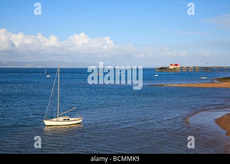 Un yacht à Mumbles Bay, station de sauvetage en arrière-plan. Swansea, Glamorganshire, pays de Galles Banque D'Images