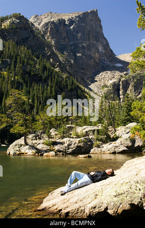 Jeune homme détente sur rive rocheuse de Dream Lake - Rocky Mountain National Park, près de Estes Park, Colorado USA Banque D'Images