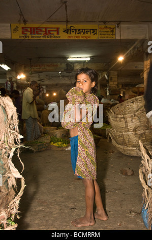 Enfant de la rue, la collecte de rebuts ou de voler de la nourriture dans le marché de nuit de Dhaka Bangladesh Banque D'Images