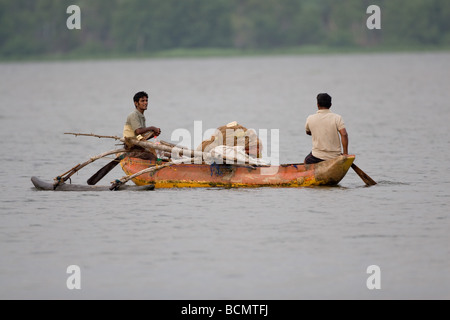 Pêcheur sur une pirogue en fibre de se préparer à poser un filet pour attraper de petits poissons et de crevettes dans la lagune de Chilaw, Sri Lanka. Banque D'Images