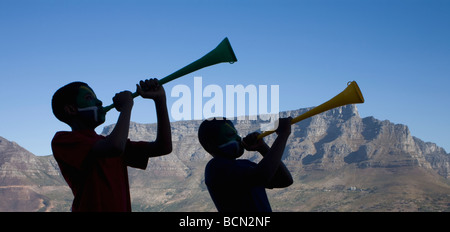 Voir la silhouette de deux garçons, les vuvuzelas souffle sur la Montagne de la table en arrière-plan Banque D'Images