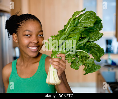 Un portrait d'une jeune femme dans la cuisine avec des feuilles de chou Banque D'Images