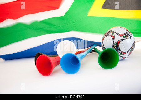 En agitant le drapeau de l'Afrique du Sud avec des vuvuzelas et un ballon de soccer shot sur fond blanc pur Banque D'Images