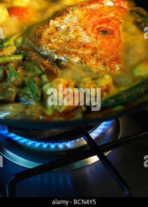 En tête de poisson au curry wok sur cooker Banque D'Images
