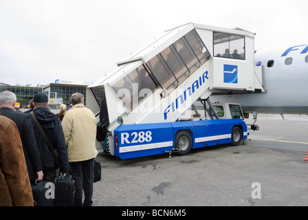 Les passagers en attente à un mobile airbridge comme ils le bord d'un jet régional. Banque D'Images