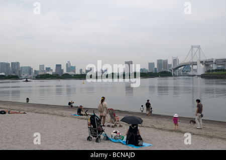 Les gens à la plage artificielle dans le parc marin d'Odaiba à travers le pont en arc-en-ciel du parc marin d'Odaiba Tokyo Japon Banque D'Images