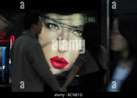 Couple holding hands in front of Dior in subway station, Shanghai, Chine Banque D'Images