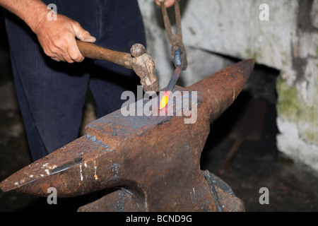 Travailler avec un marteau de forgeron sur l'enclume Banque D'Images