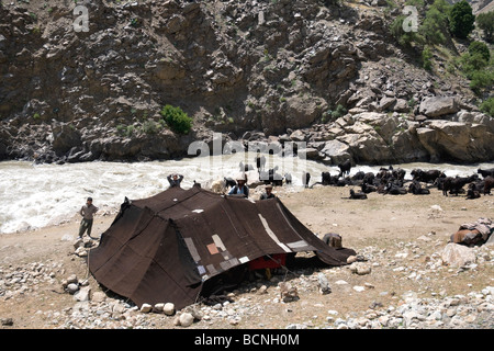 Une tente noire et des chèvres à côté le courant rapide de la rivière Panjshir marquer un camp nomade famille Kuchi Banque D'Images