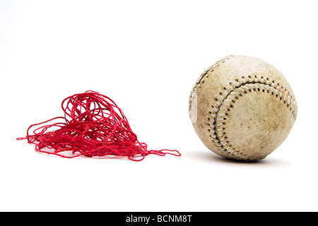 Baseball avec surpiqûres rouges vieux threads supprimés et dans une pile à côté de balle. Plafonniers vue frontale et isolé sur blanc. Banque D'Images