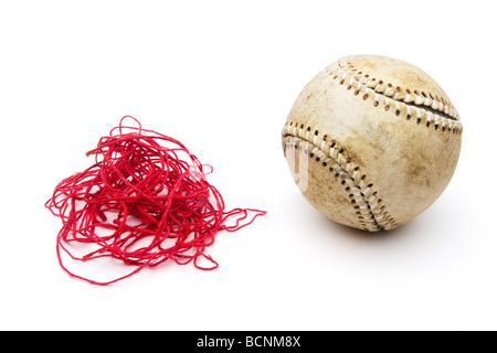 Baseball avec surpiqûres rouges vieux threads supprimés et dans une pile à côté de balle. Plafonniers vue frontale et isolé sur blanc. Banque D'Images