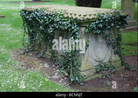 De plus en plus de lierre sur une vieille tombe dans un cimetière de l'Écossais Banque D'Images