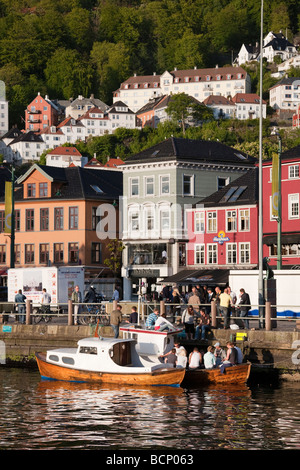 Les adolescents assis au quai du port de Bergen Norvège Banque D'Images