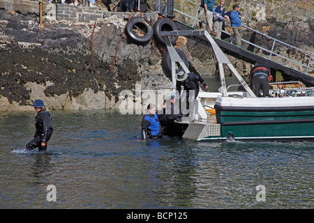 Divers équipements de plongée de chargement sur bateau dans la baie de Cardigan West Wales Banque D'Images