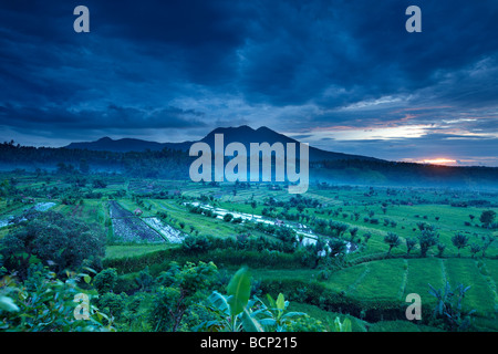 Les rizières en terrasses près de Tirtagangga à l'aube avec le soleil se lever sur le pic volcanique de Lempuyang Gunung, Bali, Indonésie Banque D'Images