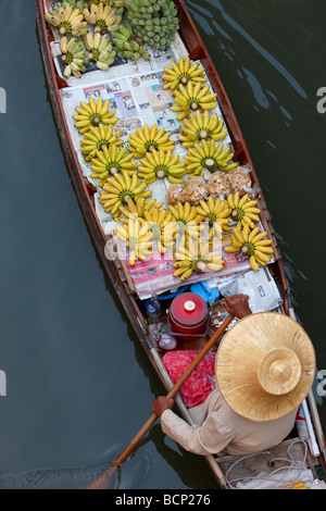 Un bateau de pagaie d'une femme vendant des bananes sur le marché flottant de Damnoen Saduak, nr Bangkok, Thaïlande Banque D'Images