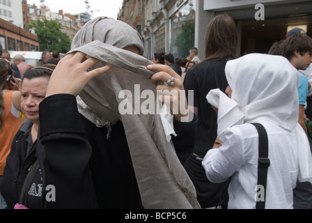 Une femme musulmane se cache derrière un foulard de hijab pour empêcher qu'une photo soit prise montrant son visage. Londres Angleterre des années 2009 2000 Royaume-Uni HOMER SYKES Banque D'Images