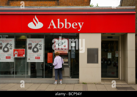 Direction générale de la Banque de l'abbaye avec une femme à un distributeur Banque D'Images