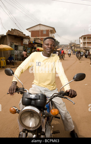 Rider boda boda sur rue dans Kamwockya Kampala Ouganda Banque D'Images