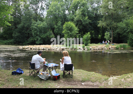 Vieux couple avoir un pique-nique sur la rivière Gartempe en France Banque D'Images